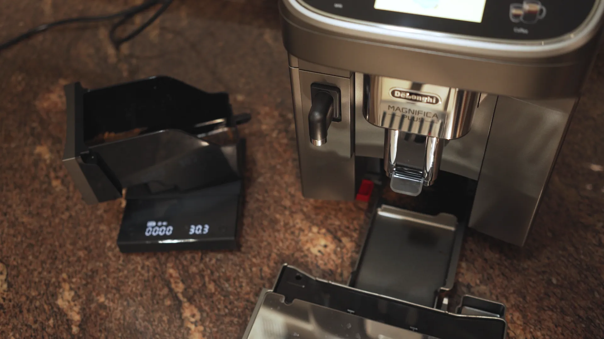 Imagen de un cajón de posos de una superautomática encima de una báscula de café.