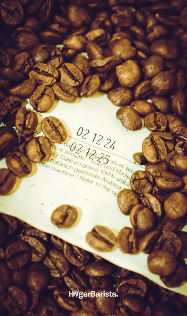 Granos de café encima de un envase donde se puede ver la fecha de tueste