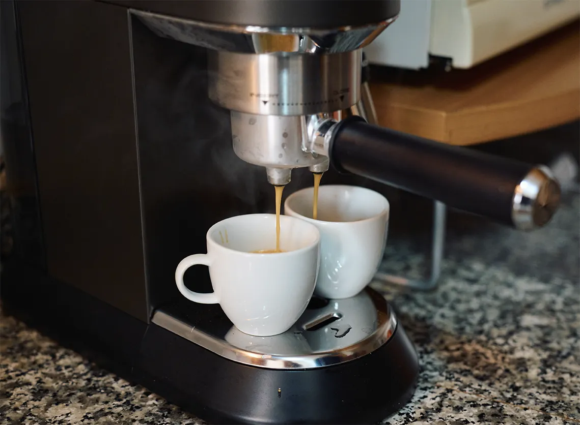 De'Longhi Dedica extracting coffee with the pressurized baskets.